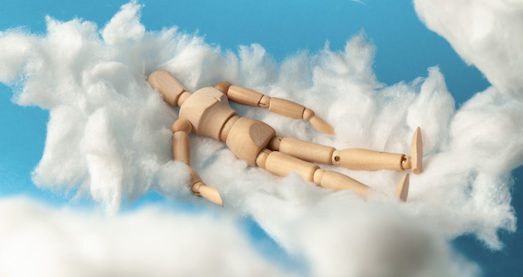 Comfortable dream of toy man on clouds, sweet dreams. Rest on bed.